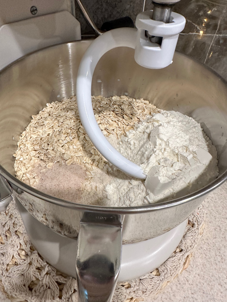 bread ingredients in bowl of stand mixer with dough hook before mixing