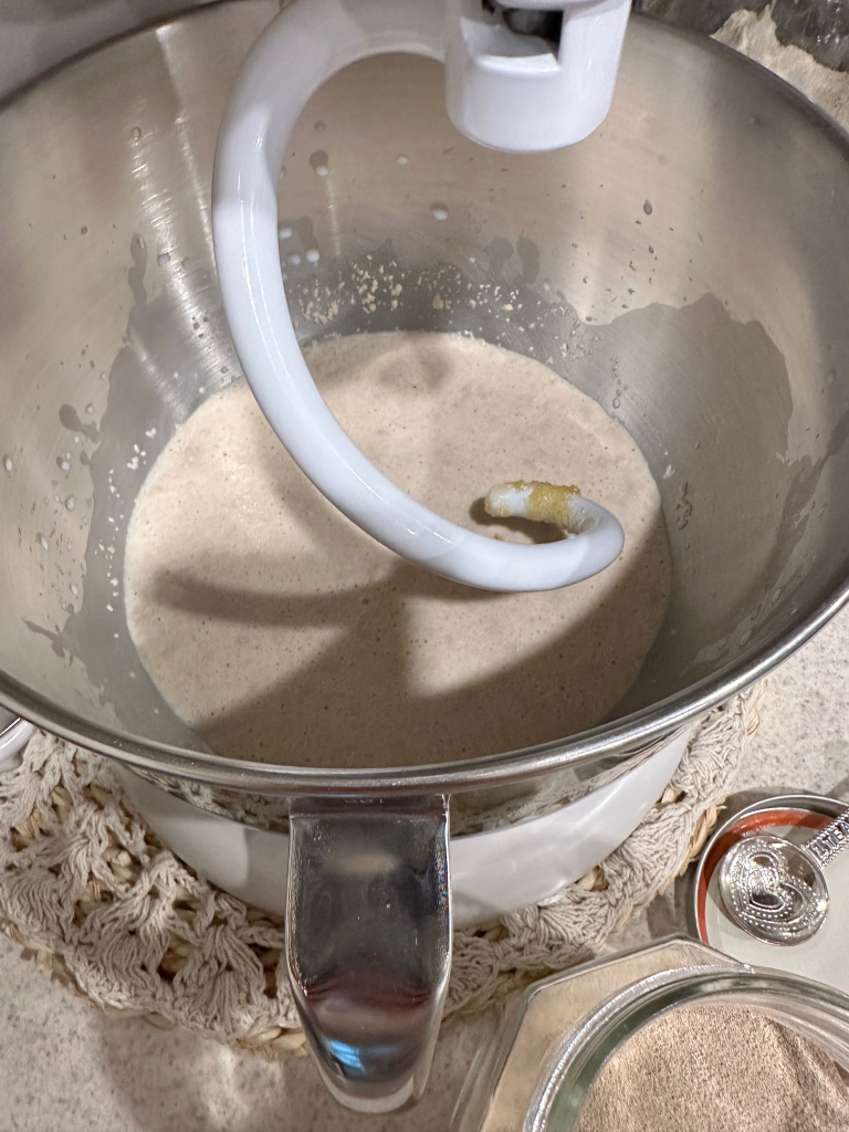 yeast mixture in bowl of stand mixer with dough hook