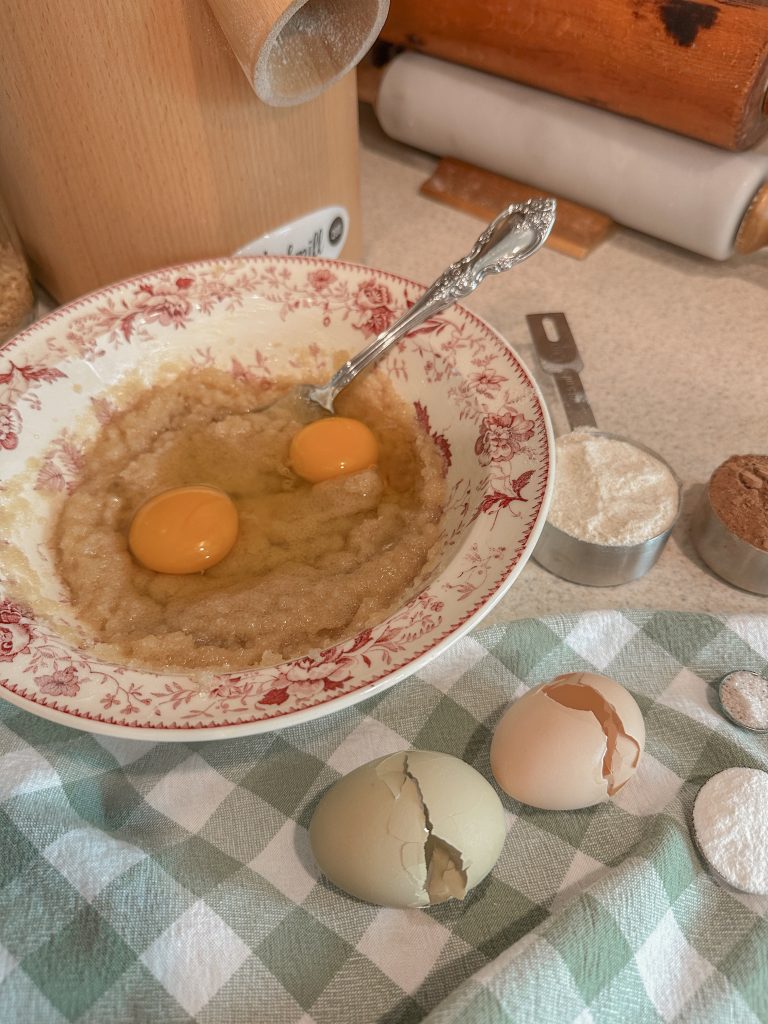 freshly milled flour brownie ingredients measured and ready to add to pink and white bowl on counter with grain mill and green and white towel