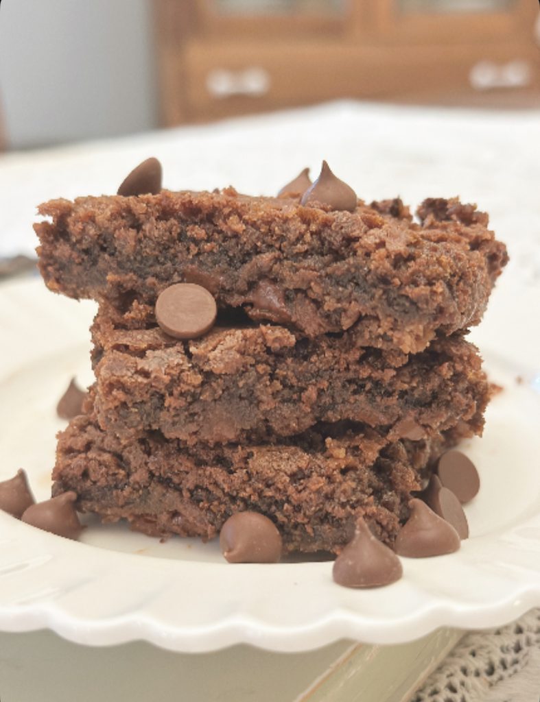 Brownies made with freshly milled flour setting on white plate with chocolate chips